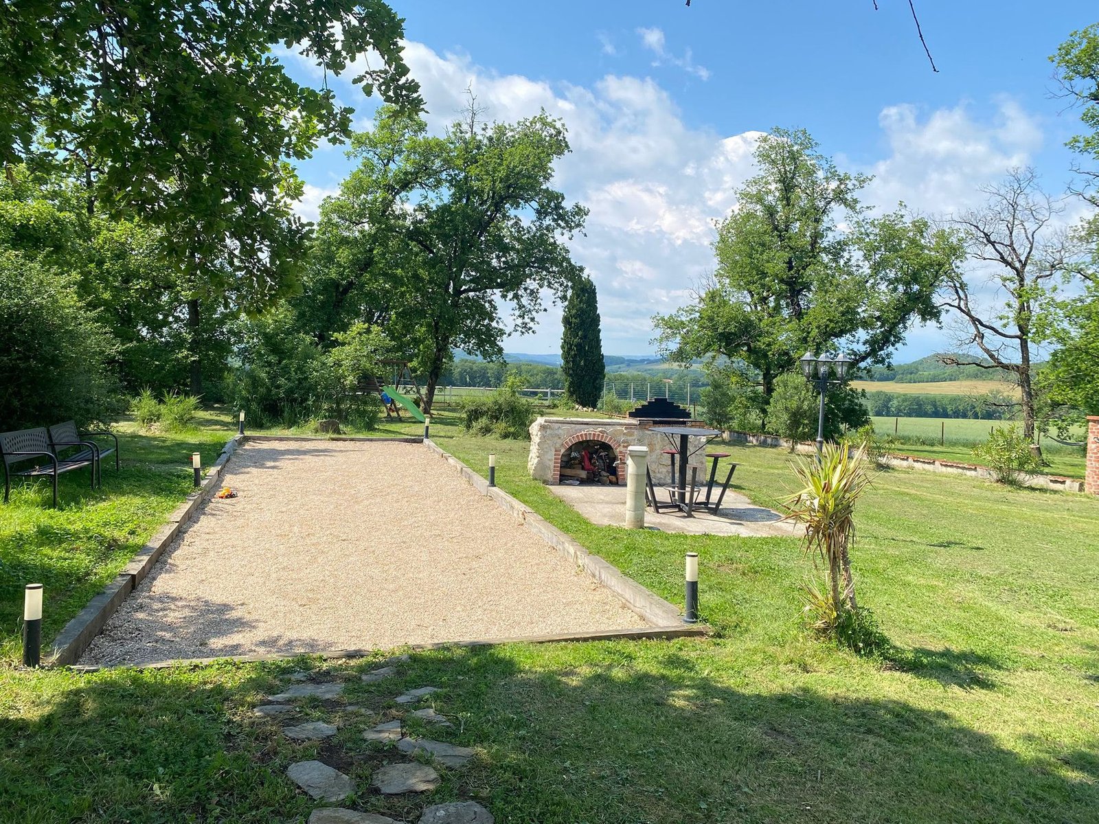 Le parc du domaine et la campagne tarnaise sous un grand ciel bleu