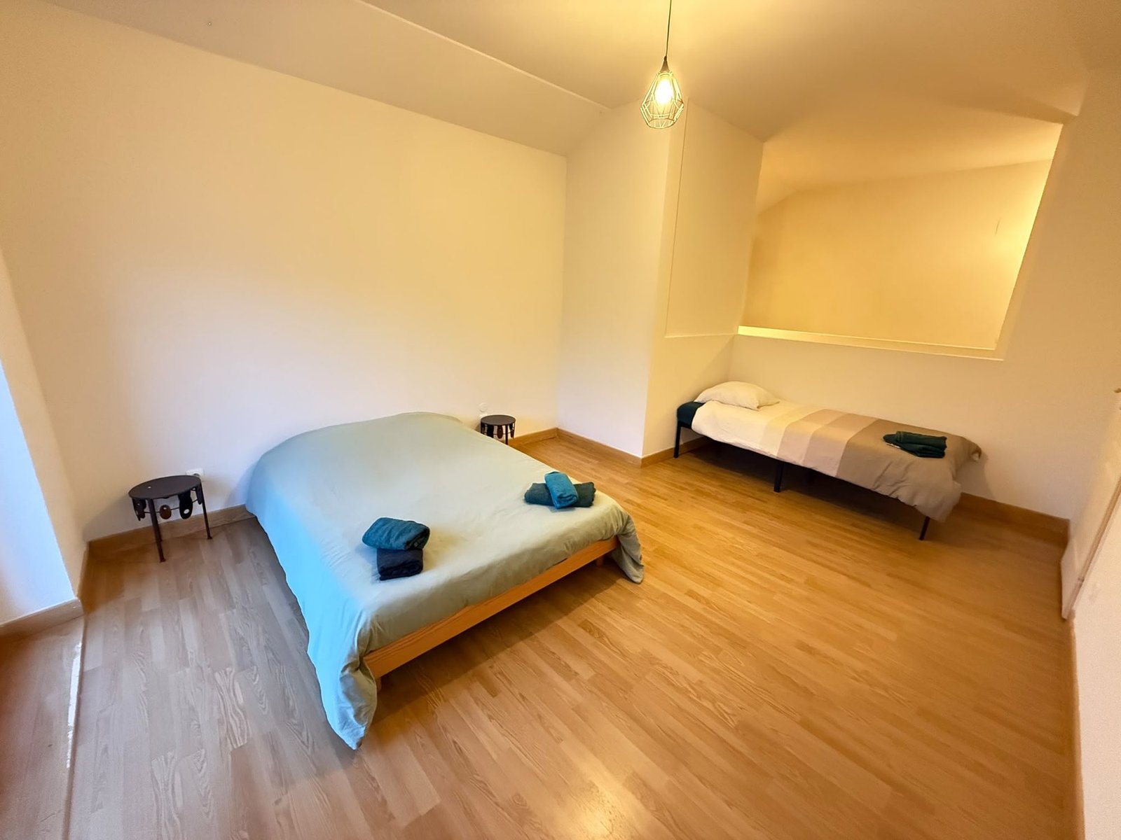 Chambre mansardée avec un lit double et un lit simple