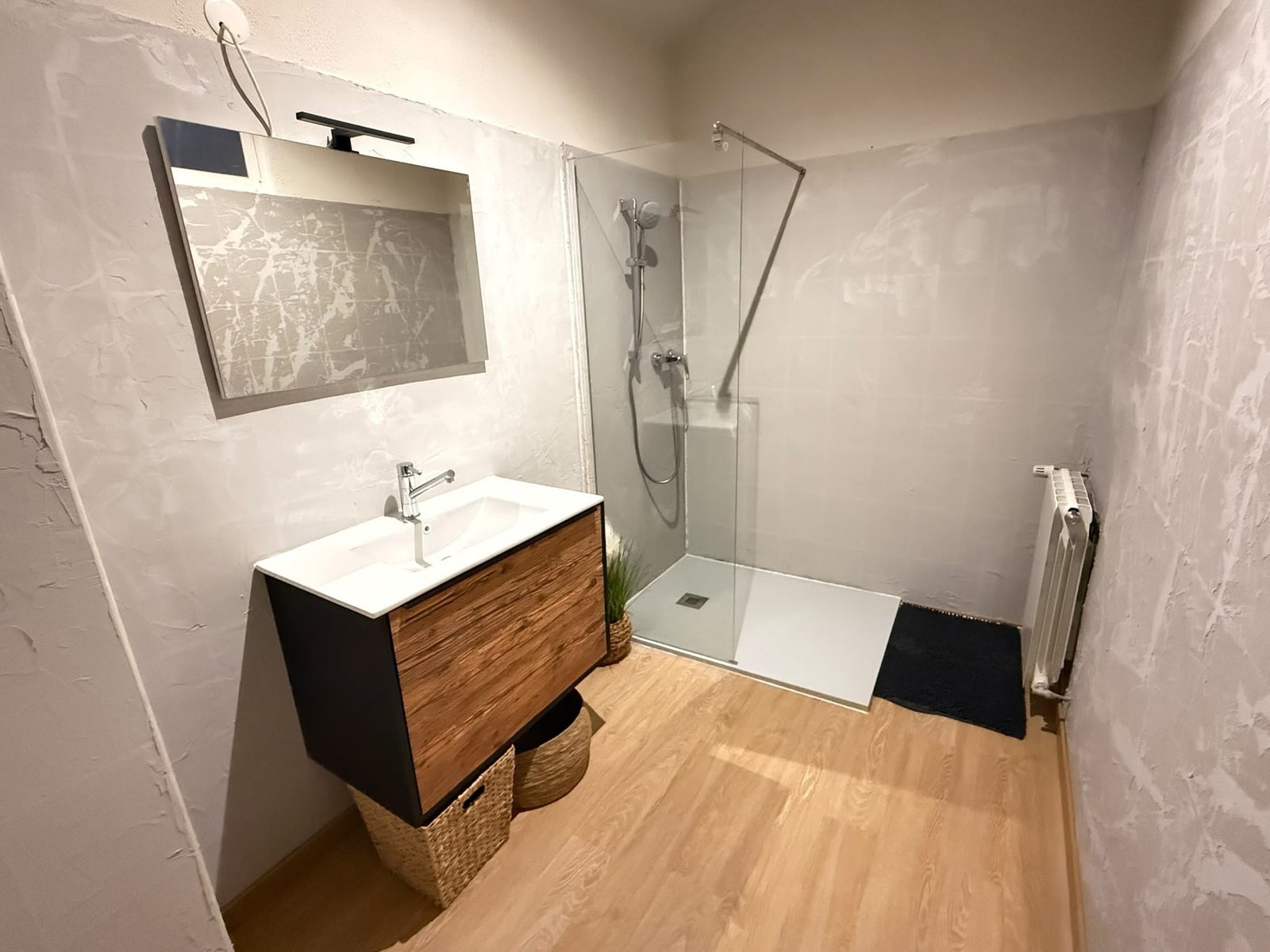 Salle de bain avec douche à l'italienne, meuble en bois et grand miroir