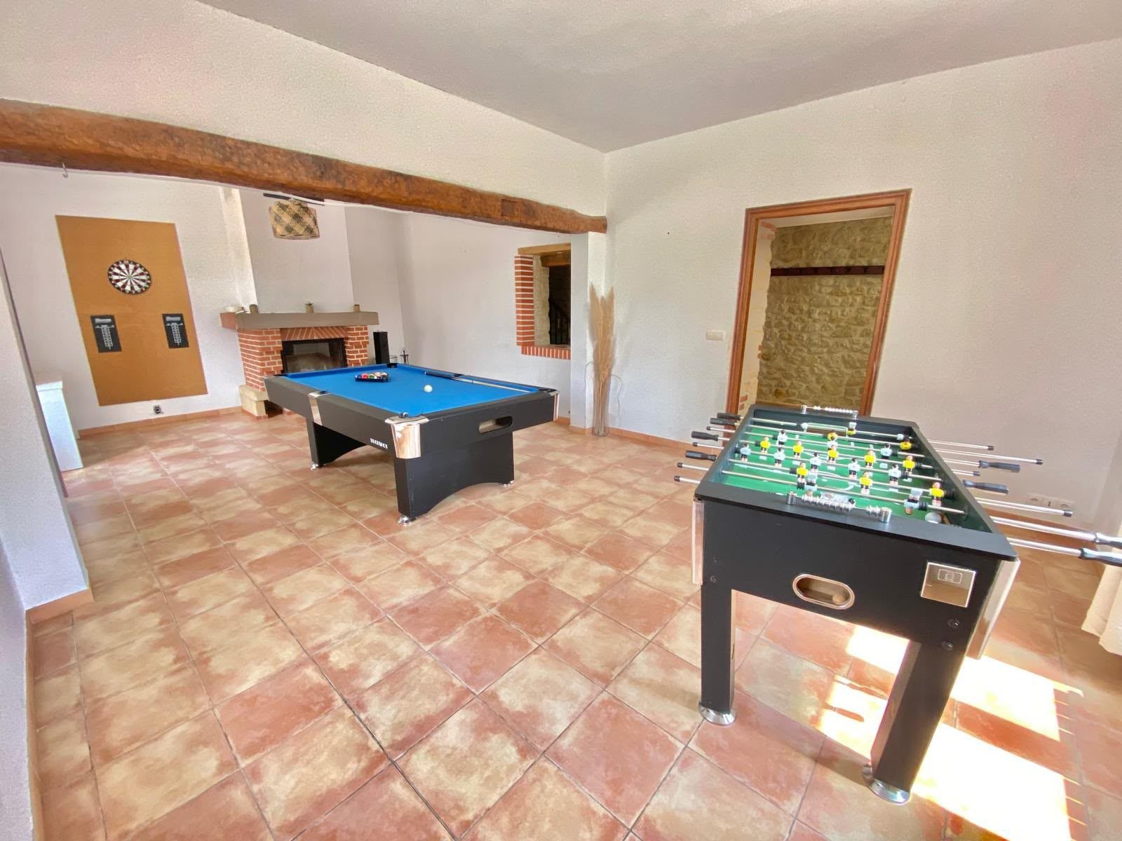 Billard, baby-foot et cible de fléchettes dans la salle de jeux